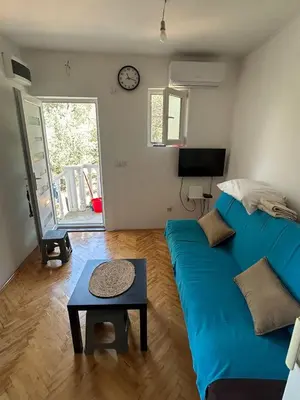 a living room with a blue couch and a table at Oliva apartment in Petrovac na Moru