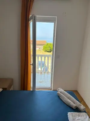 a bedroom with a bed and a door to a balcony at Oliva apartment in Petrovac na Moru