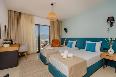 a hotel room with two beds and a desk at Hotel AQUILO in Petrovac na Moru