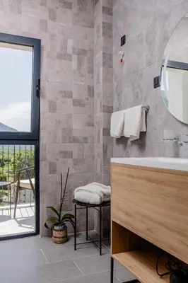 a bathroom with a tub and a sink and a window at Hotel AQUILO in Petrovac na Moru