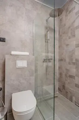 a bathroom with a toilet and a glass shower at Hotel AQUILO in Petrovac na Moru
