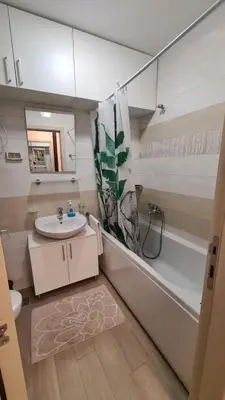 a bathroom with a sink and a tub and a toilet at Mara's cozy apartment in Podgorica