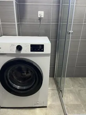 a washing machine in a bathroom with a wall at Kolibri Apartment in Dobra Voda