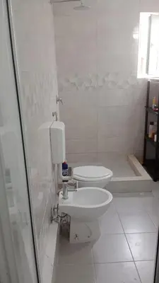 a white bathroom with a toilet and a sink at Apartmani Dream 3 in Bar, Susanj