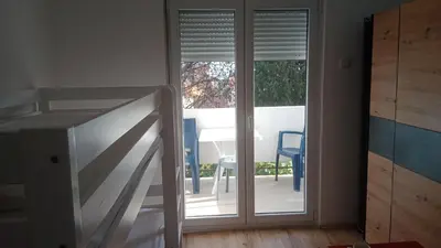 a room with a sliding glass door with a table at Apartmani Dream 3 in Bar, Susanj