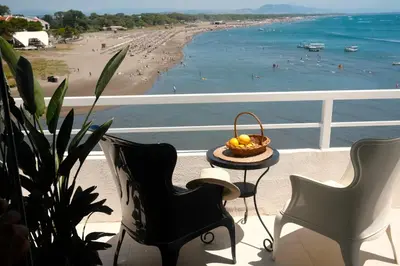 a balcony with a table and chairs and a beach at Palastura Apartments in Ulcinj