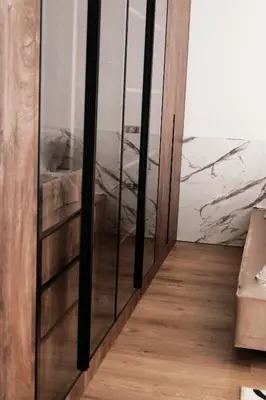 a glass door in a room with a wooden floor at Palastura Apartments in Ulcinj