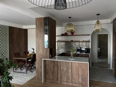 a kitchen with wooden cabinets and a dining room at Palastura Apartments in Ulcinj