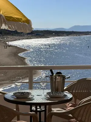 a table with wine glasses and a bucket on the beach at Palastura Apartments in Ulcinj