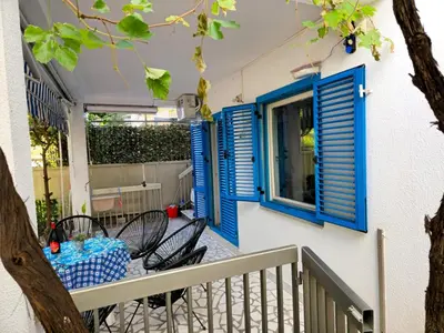 a balcony with blue shutters and a table and chairs at Hostel Budva in Budva