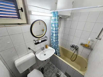 a bathroom with a sink and a mirror and a tub at Hostel Budva in Budva