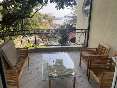 a patio with chairs and a glass table and a balcony at Apart Yukka first line in Utjeha