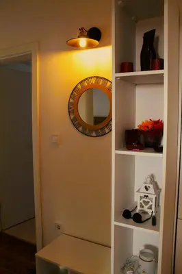 a mirror on a wall next to a shelf at Mantra HOME in Bar