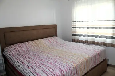 a bedroom with a bed and a window with a blanket at Mantra HOME in Bar