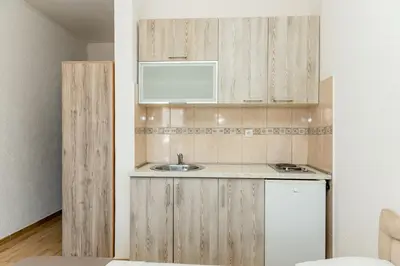 a kitchen with wooden cabinets and a sink at Kraja Apartments in Ulcinj