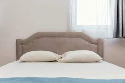 a bed with two pillows and a headboard at Kraja Apartments in Ulcinj