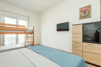 a bedroom with a bunk bed and a flat screen tv at Kraja Apartments in Ulcinj
