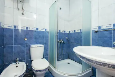 a blue and white bathroom with a toilet and a sink at Kraja Apartments in Ulcinj