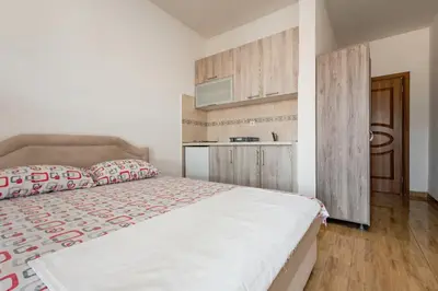 a bedroom with a large bed and a kitchen at Kraja Apartments in Ulcinj