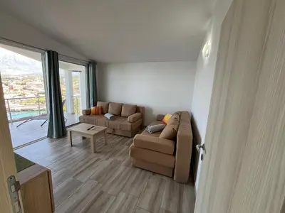a living room with a couch and a table at Jakovljevic apartman in Utjeha