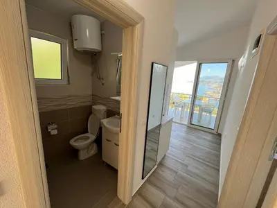 a bathroom with a toilet and a window at Jakovljevic apartman in Utjeha