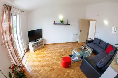 a living room with a couch and a television at Apartments Vila Masha in Petrovac na Moru