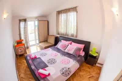 a bedroom with a large bed with pink pillows at Apartments Vila Masha in Petrovac na Moru