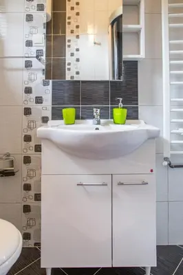 a white bathroom with a sink and a mirror at Apartments Vila Masha in Petrovac na Moru