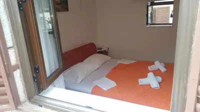 a reflection of a bedroom with a bed in a mirror at Guest House Ivo Jovanovic in Sveti Stefan