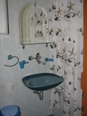 a bathroom with a sink and a shower curtain at Guest House Ivo Jovanovic in Sveti Stefan