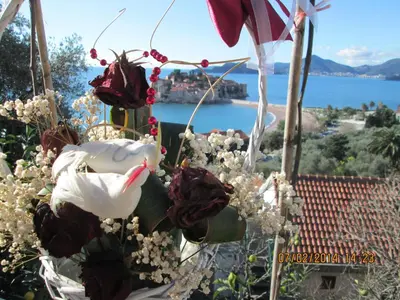 a bouquet of flowers with a view of the water at Guest House Ivo Jovanovic in Sveti Stefan