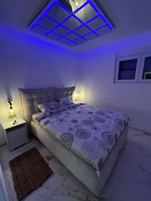 a bedroom with a bed with a blue light at One bedroom apartments Budva in Budva