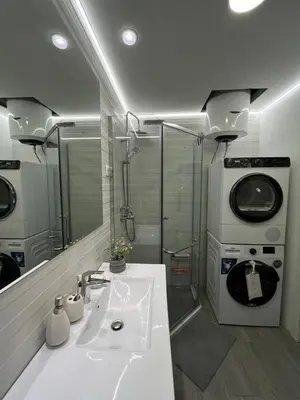 a bathroom with a sink and a washing machine at One bedroom apartments Budva in Budva