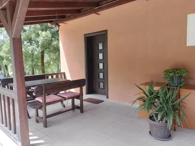 a porch with a wooden bench and a table at Oasis of Peace Meterizi in Cetinje
