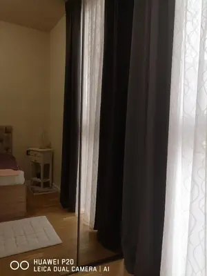 a bedroom with black and white curtains and a bed at Život je tren in Podgorica