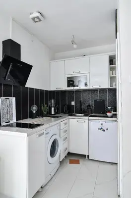 a kitchen with white cabinets and a washer and dryer at La splendida in Becici