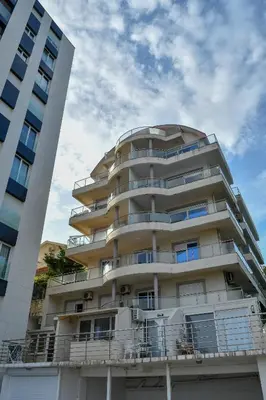 a tall white building with balconies on it at La splendida in Becici