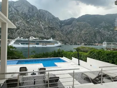 a cruise ship in the water next to a swimming pool at Luxury Kotor bay view studio in Muo