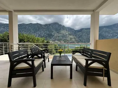 a balcony with three benches and a table with a view at Luxury Kotor bay view studio in Muo