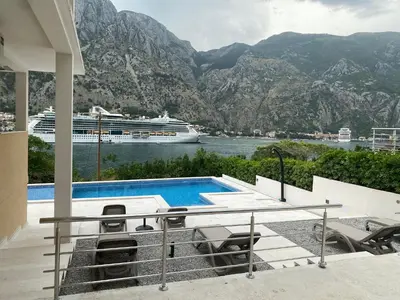 a cruise ship in the water next to a swimming pool at Luxury Kotor bay view studio in Muo