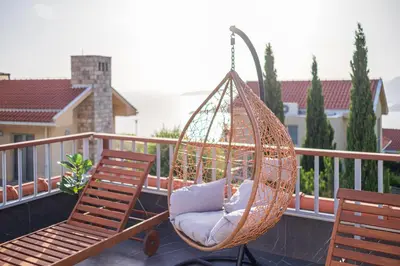 a porch with two chairs and a hammock on a balcony at Carsko Selo Budva Blizikuce Soppp in Ðenaši
