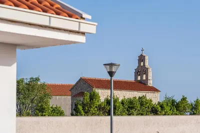 a street light in front of a church with a tower at Carsko Selo Budva Blizikuce Soppp in Ðenaši