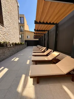 a row of chaise lounges on the side of a building at Giardino Onia Apartment in Budva