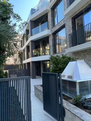 an apartment building with a fence in front of it at Giardino Onia Apartment in Budva