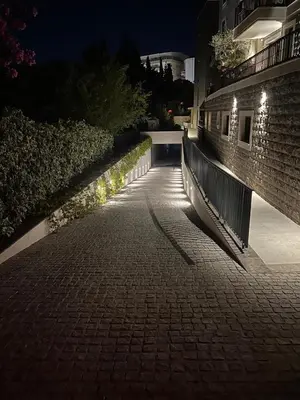 a brick walkway with lights on the side of a building at Giardino Onia Apartment in Budva