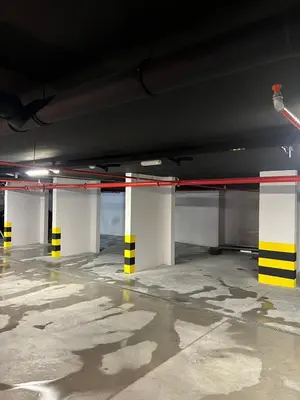 a parking garage with white and yellow columns at Giardino Onia Apartment in Budva