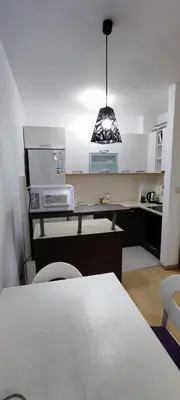 a kitchen with a table and a counter top at Vacation Apartment City Kvart in Podgorica