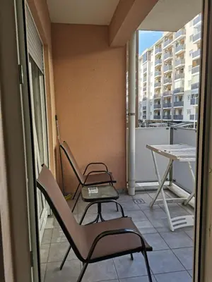 two chairs and a table on the balcony of a building at Vacation Apartment City Kvart in Podgorica