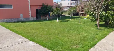 a yard with green grass and trees next to a building at Apartment Diki in Bar