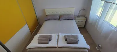a small bedroom with a bed with two pillows at Apartment Diki in Bar